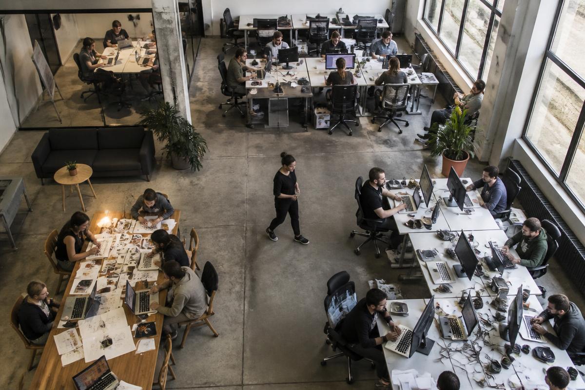 Overhead view of separate teams doing different work across one large office